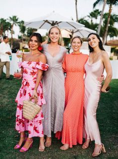 three beautiful women standing next to each other in front of palm trees and umbrellas