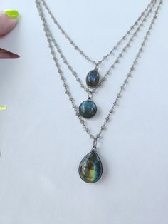 This necklace has three beautiful dynamic labradorite stones that are hung on silver chains covered in rainbow moonstone. The 3 center labradorite stones are also framed in silver. No pictures could do this necklace justice with every movement new rainbows appears! Iridescent Labradorite Pendant Necklace, Handmade Iridescent Labradorite Necklace, Silver Gemstone Necklace For Layering, Mystical Silver Gemstone Bead Necklace, Mystical Silver Necklace With Gemstone Beads, Silver Faceted Labradorite Jewelry, Silver Labradorite Teardrop Pendant Necklace, Silver Labradorite Teardrop Necklace, Iridescent Labradorite Pendant Jewelry