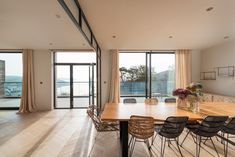 a dining room table and chairs in front of large windows