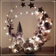 a christmas wreath with lights and ornaments in the shape of a deer on top of it