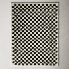 a black and white checkered rug on a wall