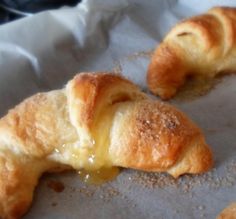 two croissants sitting on top of a piece of wax paper next to each other