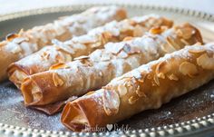 some food is on a silver plate and it looks like they have been rolled up