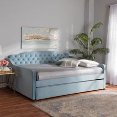 a bedroom with a blue bed frame and matching daybed, side tables and rugs