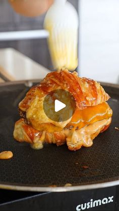 a close up of food on a pan with a blender in the back ground