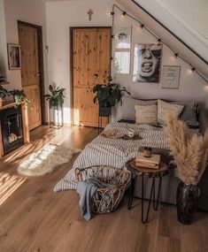 a bed sitting in the middle of a living room next to a fire place and wooden floors