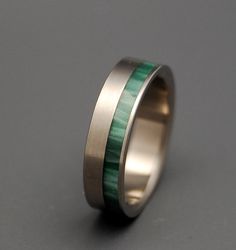 a wedding ring with green wood inlays on the inside and silver bands around it