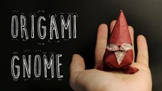 an origami gnome sitting in someone's hand with the word gnome on it