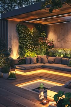 an outdoor living area with couches and plants lit up at night, surrounded by greenery