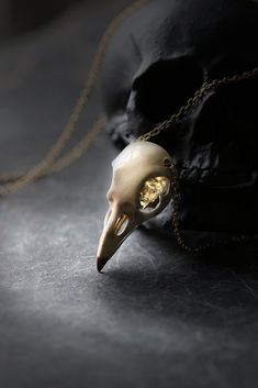 ** Painting Raven Skull charm Necklace original design and made by Defy ** Another Skull charm signature from our animal anatomy collections. The skull pendant has nice handmade carving details with hand painting on surface. The pendant material is brass with acrylic paint. The chain is made of gold-plated on brass. - The raven skull dimensions : approx. 1.6 x 3.6 x 1.6 cm. - The necklace chain length : please choose from our options. - Weight : 15 g. - Claw clasp - Material : Brass / Silver **S Hand Cast Skull Necklace As Gift, Bronze Skull Jewelry For Gifts, Bronze Skull-shaped Jewelry Gift, Bronze Skull Jewelry Gift, Hand Cast Skull Necklace For Gift, Skull-shaped Bone Jewelry For Gifts, Bone-colored Skull Jewelry For Gift, Skull Shaped Bone Colored Jewelry For Gifts, Bone Color Skull Jewelry For Gifts