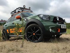 an suv parked on the side of a dirt road with skis on top of it