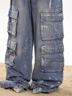 Stay on trend with these relaxed baggy cargo denim pants. Featuring a wide leg and cargo pockets for practicality, add some edge to your look with the paint splatter and distressed details. Relaxed, baggy fit Wide leg silhouette Multiple oversized cargo pockets Distressed blue wash with paint splatter effect Model is 5'4 95lbs wearing M Grunge Wide-leg Jeans With Cargo Pockets, Grunge Wide Leg Jeans With Cargo Pockets, Baggy Medium Wash Cargo Jeans In Grunge Style, Distressed Denim Blue Cargo Jeans In Grunge Style, Distressed Denim Blue Grunge Cargo Jeans, Baggy Grunge Cargo Jeans In Medium Wash, Trendy Distressed Cargo Pants For Streetwear, Grunge Wide-leg Denim Cargo Jeans, Grunge Wide Leg Denim Cargo Jeans