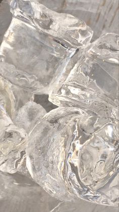 some ice cubes are sitting on top of each other in a glass bowl with water