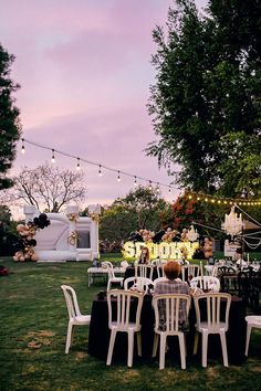 a group of white chairs sitting on top of a lush green field