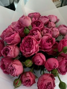 a bouquet of pink roses sitting on top of a table