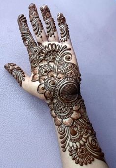 a henna on someone's hand with intricate designs