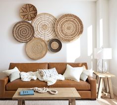 a living room filled with furniture and lots of wicker baskets hanging on the wall