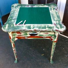 an old green table with some paint on it