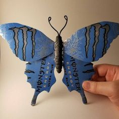 a hand holding a blue and black butterfly with the word detroit on it's wings