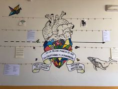 there is a mural on the wall in this school's hallway that has been decorated with colorful images and banners