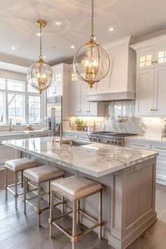 a large kitchen with marble counter tops and stools in front of the center island