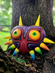 a colorful mask sitting on top of a tree