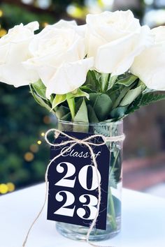 white roses in a vase with a price tag