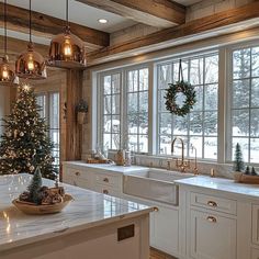 a christmas tree is in the middle of a kitchen with white cabinets and counter tops