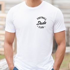 The Football Dads Club tee is a classic jersey short sleeve t-shirt that fits like a well-loved favorite. Perfect for active and leisure this t-shirt makes a great game day football shirt for dad or football season shirt for dads with kids playing football. Soft cotton and quality print make you fall in love with it over and over again. .: Crew neckline .: Made with 100% Airlume combed and ring-spun cotton .: Lightweight fabric that is breathable and easy to layer .: Sustainable manufacturing .: Ribbed knit collar with seam .: The tear-away label minimizes skin irritations ---------------------- SHIPPING INFO ---------------------- Please allow 1-3 days to print and process your order. From there shipping time for your order is approximately 2-5 business days. Once shipped you'll receive t Team Spirit Short Sleeve T-shirt With Logo, Pre-shrunk White Print Crew Neck T-shirt, White Crew Neck T-shirt With Team Spirit, Team Spirit Text Print Crew Neck T-shirt, Crew Neck T-shirt With Team Spirit Text, Father's Day Fan Merchandise Crew Neck T-shirt, Father's Day Fan Merchandise T-shirt With Crew Neck, Crew Neck T-shirt With Name Print For Fans, Short Sleeve Shirt With Logo For Sports Events