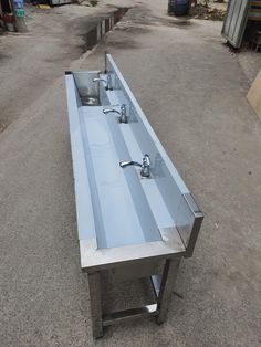 two stainless steel sinks sitting in the middle of a parking lot