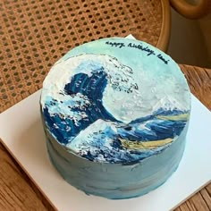 a birthday cake decorated with an image of the great wave on it's side