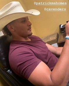 a man sitting in a chair with a cowboy hat on