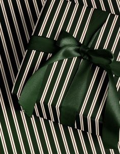 a green and white striped gift box with a bow