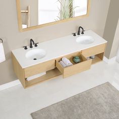 a bathroom with two sinks and a large mirror above the sink, in front of a white rug