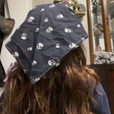 a woman with long hair wearing a skull and crossbones print bandana on her head