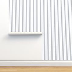 an empty room with a white wall and wooden floor next to a radiator