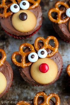 some cupcakes with chocolate frosting and pretzels in the shape of reindeer heads