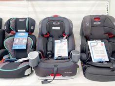 three rows of baby carseats on display at a car dealership, with price tags attached to them