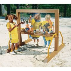 three children standing in front of a table with pictures on it