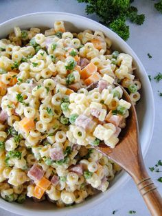 a white bowl filled with macaroni salad next to broccoli