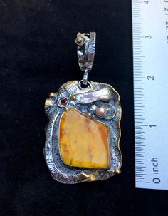 "Artisan Amber gemstone pendant Hand-made Sterling Silver 925,24k Gold Stones used: Baltic Amber, Pearls, Garnet Height - 3\" (with bail), Width - 1 1/2\" Height -75mm (with bail), Width - 38mm Unique Handcrafted One-of a-kind Design Pendant Each Piece of Jewelry in my Collection is Absolutely One of a Kind! When you start wearing a piece of my jewelry you will fall in love with it more and more each day and feel that good Energy and Love that I pass into it while creating this piece of Art. A p Unique Polished Pendant Necklace, Artisan Pendant Jewelry With Polished Finish, Hand Forged Amber Sterling Silver Jewelry, Handmade Amber Necklace For Anniversary, Artistic Gold Jewelry With Cabochon, Antique Yellow Pendant Jewelry, Yellow Gemstone Fusion Jewelry, Yellow Citrine Cabochon Jewelry, Handmade Antique Jewelry With Rectangular Pendant