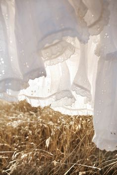 some white dresses are hanging in the grass