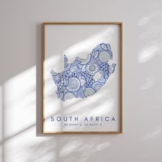 a blue and white poster hanging on the wall next to a wooden frame with an african map