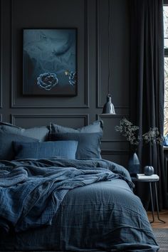 a bedroom with black walls and blue linens on the bed is pictured in this image