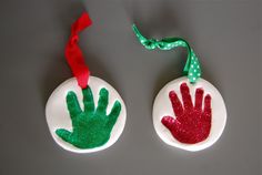 two handprinted christmas ornaments with red and green hands