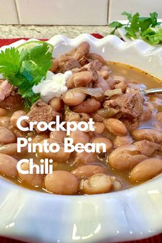 A bowl of pinto bean chili with sour cream and fresh cilantro and a spoon. Chili Recipe Without Tomatoes, Pinto Bean Chili Recipe, Pinto Bean Chili, Homemade Honey Butter, Pinto Bean Soup, Beans And Sausage