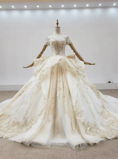 a wedding dress on display in a room with white walls and floor to ceiling lighting