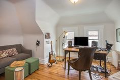 a living room filled with furniture and a flat screen tv sitting on top of a wooden floor