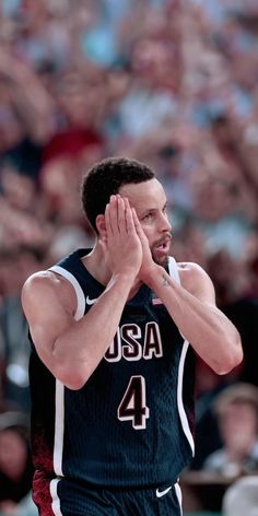 a basketball player is applauding the crowd with his hands in front of him