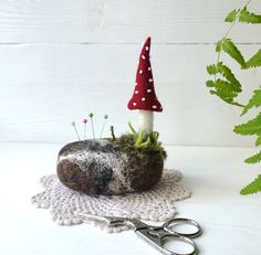 a small mushroom sitting on top of a rock next to scissors